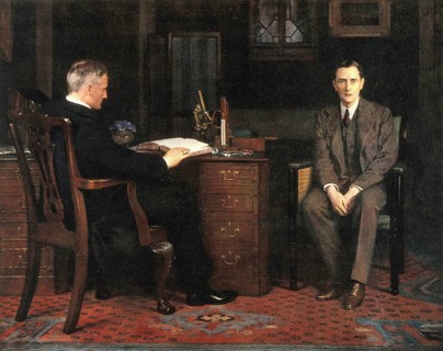 Two men are in an office, one sitting at a desk and the other on a chair, engrossed in a