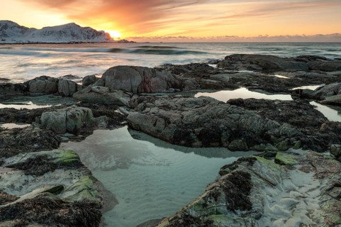 Sunset in winter at Skagsanden, rocks on the beach at Flakstad, Flakstadøy, Lofoten, Nordland,