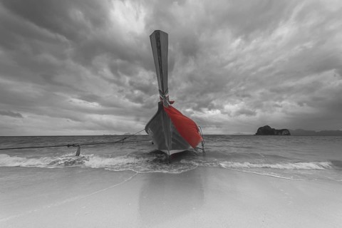 Longtail boat on the beach, dark rain clouds behind, Koh Ngai Island, Andaman Sea, Satun Province,