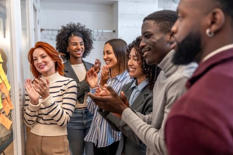 Diverse teamwork applauding at the end of a brainstorming meeting in a coworking space