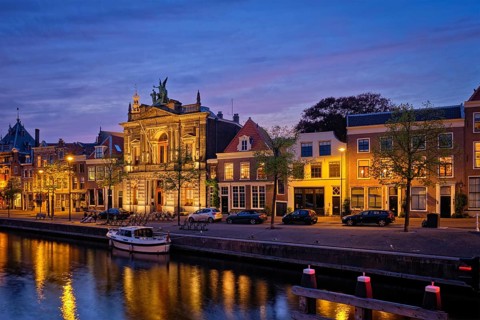 Canal with boats and houses illuminated in the evening. Haarlem, Netherlands
