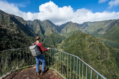 Tourist at a viewpoint, view from the Miradouro dos Balcões, densely overgrown steep mountains,