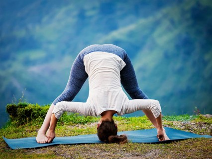 Yoga exercise outdoors, woman doing Ashtanga Vinyasa Yoga asana Prasarita padottanasana D, wide
