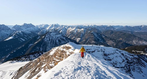 Ski tourers at the summit of Schafreuter, view of snow-covered mountain panorama, Karwendel, Tyrol,