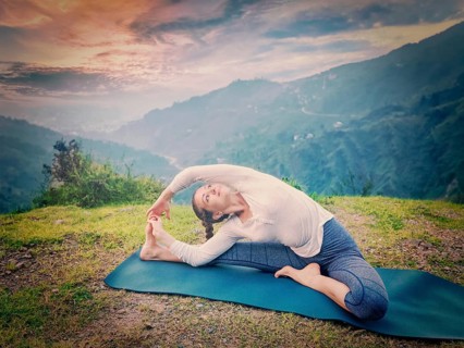 Yoga outdoors, young sporty fit woman doing Hatha Yoga asana janu sirsasana, Revolved Head-to-Knee