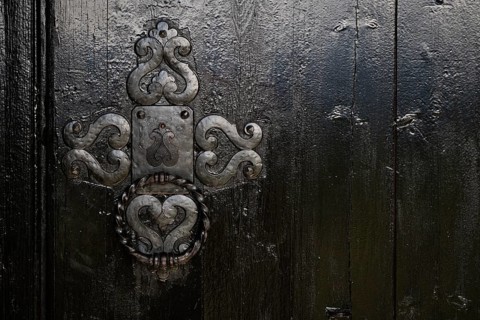 Ornate wooden door with wrought-iron, richly decorated fittings, backdrop Kristin Lavranstochter