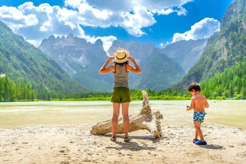 Mother and son enjoying a sunny day at lago di landro, surrounded by the stunning dolomites in