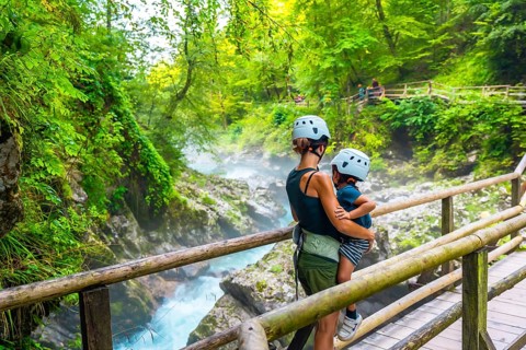 Mother holding her child while admiring the stunning vintgar gorge near bled, slovenia, during