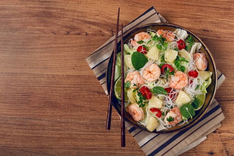 Thai salad with shrimp and rice noodles, pineapple slices, coriander and mint leaves, homemade, no