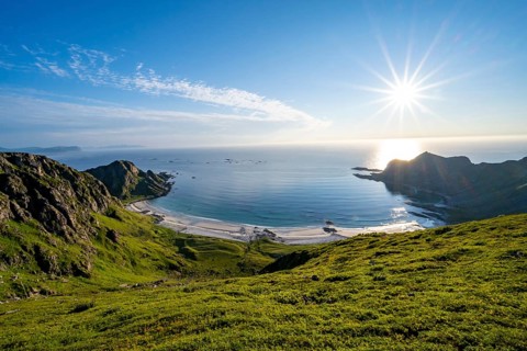 View of picturesque coastal landscape with sun star, Høyvika beach and sea, hike to the summit of
