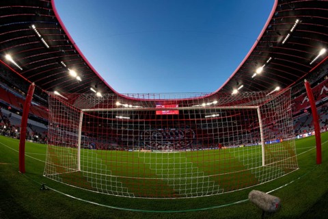Overview, interior, floodlit match, behind-the-goal perspective, goal net, blue hour, fisheye shot,