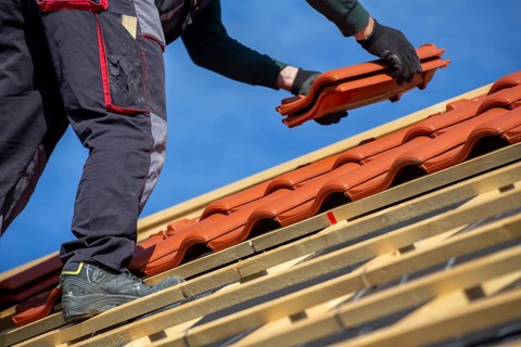 Roofer covering a tiled roof