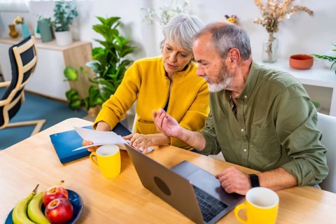 Elevated view of a caucasian senior couple doing the household accounting with laptop