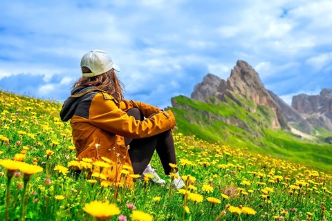 Female hiker enjoying the breathtaking view of the seceda mountain range in the dolomites, italy,