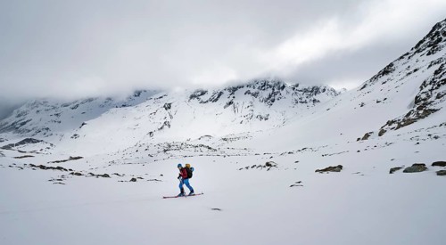 Ski tourers in a wintry mountain landscape with cloudy mountain peaks, ascent to Piz Laviner,