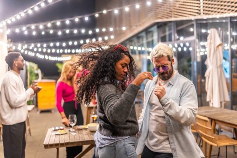 Multi-ethnic friends dancing salsa in the terrace of a night bar