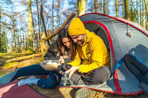 Couple enjoying a moment together while reviewing mushroom photos on a digital camera during a