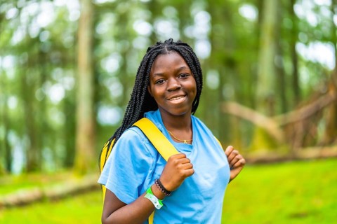 Horizontal close-up portrait of cheerful young african female hiker
