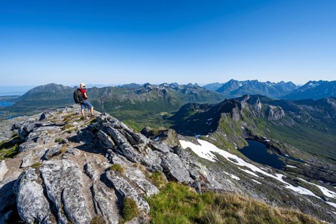 View of mountains and fjord landscape, mountaineers at the summit of Rundfjellet, Lake