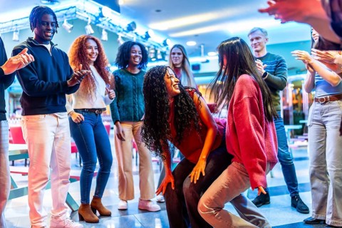 Young people having fun dancing at the bowling alley, enjoying their weekend together with energy