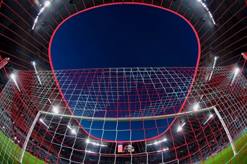 Overview, interior, floodlit match, behind-the-goal perspective, goal net, blue hour, fisheye shot,