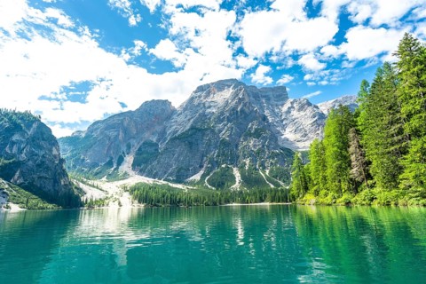 Emerald waters reflecting the majestic dolomites peaks at lake braies, a stunning natural wonder in