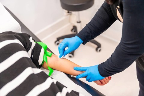 Woman lying on stretcher ready for blood extraction in a baldness treatment clinic