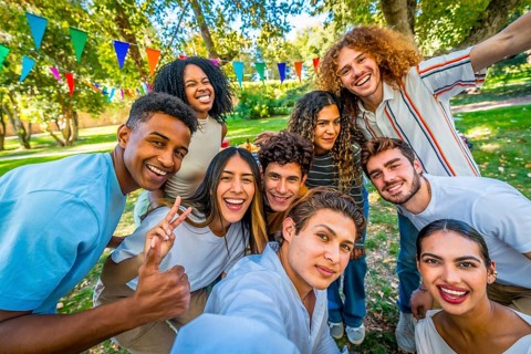 Frontal personal perspective view of happy young multi-ethnic students taking selfie celebrating