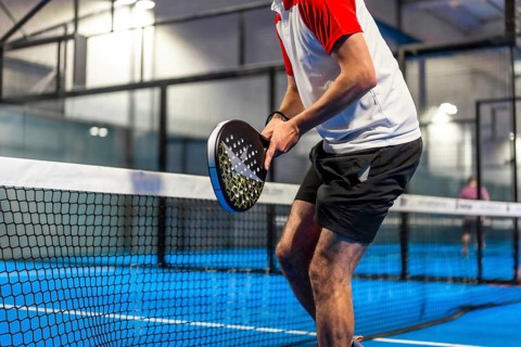 Cropped photo of an unrecognizable sportive man playing paddle tennis indoors