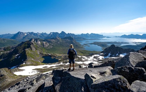 View of mountains and fjord landscape, mountain panorama, mountaineer at the summit of Rundfjellet,