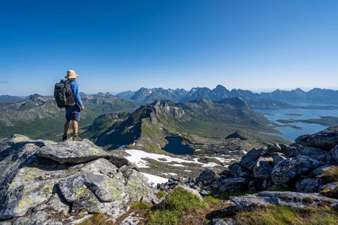 View of mountain landscape, mountain panorama, mountaineer at the summit of Rundfjellet, lake
