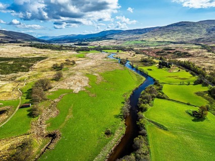 Farms and Mountains over River Dochart and Road A85 from a drone, Perthshire, Scotland, UK