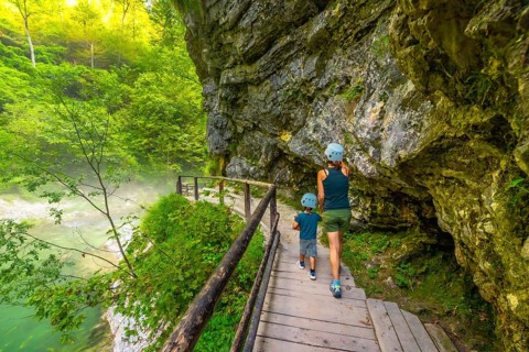 Tourists wearing helmets are enjoying a hike through the scenic vintgar gorge near bled, slovenia,
