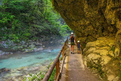 Tourists walking along the radovna river in vintgar gorge, near bled, slovenia, enjoying the