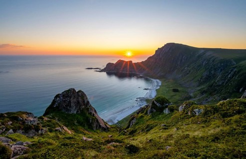 View of coastal landscape at sunset, cliffs and summit of Måtind or Måtinden, Høyvika beach and
