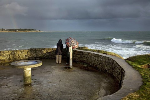 Tourists looking at sea in bad weather from the Pointe de Combrit near Bénodet, Finistère,