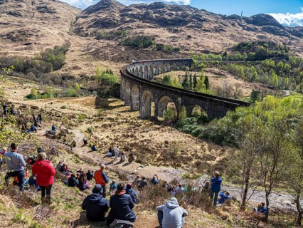 Tourists waiting for the jacobite steam train at the Glenfinnan viaduct, scottish highland,