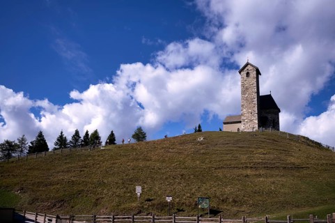 Hikers in front of St. Vigilius church, Vigilius on the yoke, faith trail, near Lana, South Tyrol,