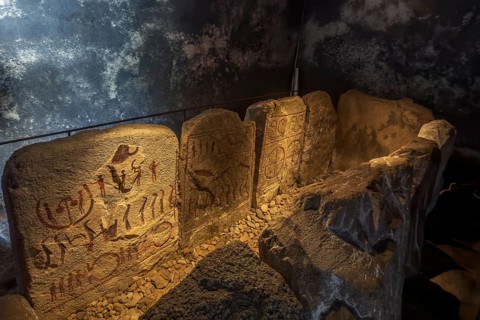 Carved figures in stone slabs inside the King's Tomb, a Bronze Age tomb in Kivik, Simrishamn
