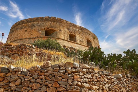 An old round tower on a hill with cacti and a clear blue sky, Venetian Sea Fortress, Leper Island,