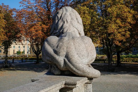 Resting lion made of granite on the terraced base of the equestrian statue of Emperor Wilhelm I on