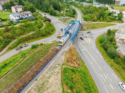 Railway line and train on a bridge over a road crossing, track construction, rail delivery for