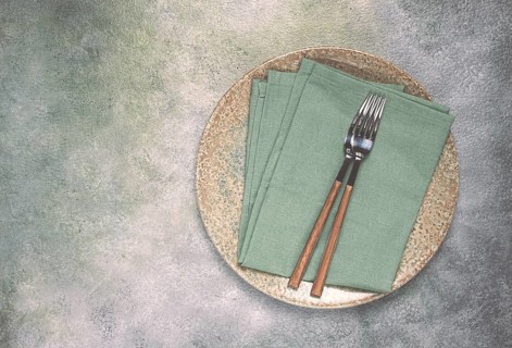 A plate with a kitchen towel and two forks, food wallpaper, food concept, top view, no people