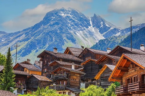 Nested old wooden houses, behind the summit of the Scex de Marenda mountain, historic village