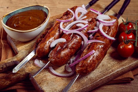Fried sausages, in English with bacon, for grilling, on a cutting board, top view, no people