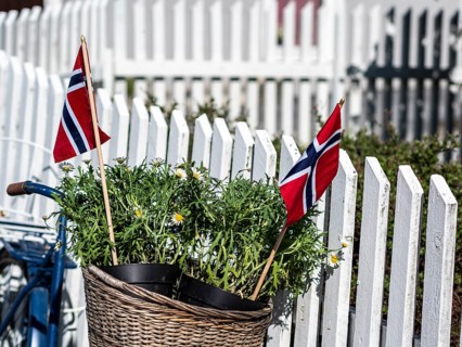 Decorated bicycle at a white fence, norwegian national day, village Solvorn at the Sognefjord,