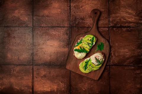 Sandwich with cream cheese, sliced avocado and boiled egg, arugula, on grainy bread, homemade,