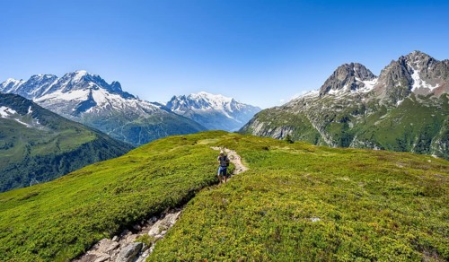 Mountaineer on hiking trail, mountain panorama with glaciated mountain peaks, Aiguille Verte with