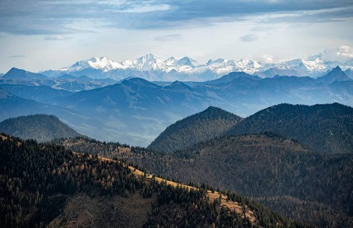View of the Alpine foothills and main Alpine ridge with snow-covered peaks, summit of the Hohe