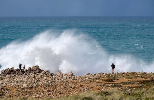 Carrapateira, Algarve, Portugal - Tourists on a viewing platform marvel at the roaring surf and